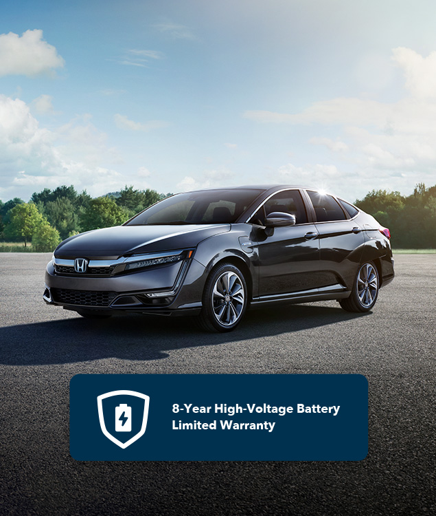 Front of 2021 Clarity Plug-In Hybrid in Modern Steel Metallic driving on highway along lake.